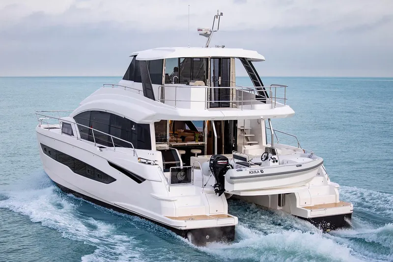 Slide: The Image of Manufacturer Provided Image: 2026 Aquila 54 Yacht cruising on open water, rear view. - 2