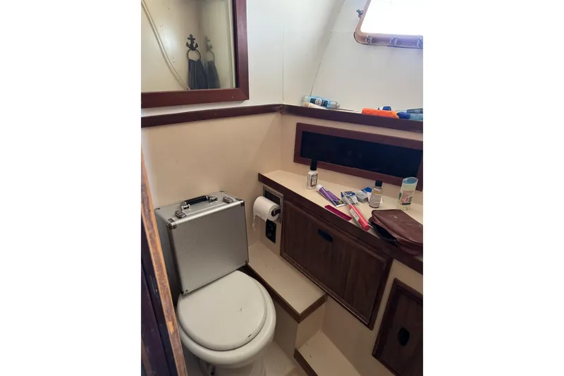 Slide: The Image of 1977 Pacifica 44 Convertible boat bathroom with toilet, mirror, and toiletries. - 17