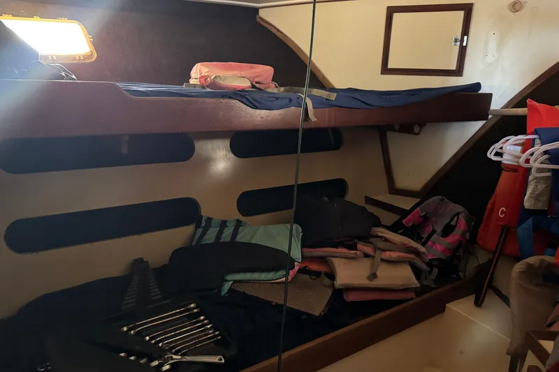 Slide: The Image of Interior cabin of a 1977 Pacifica 44 Convertible boat with bunk beds and life jackets. - 18