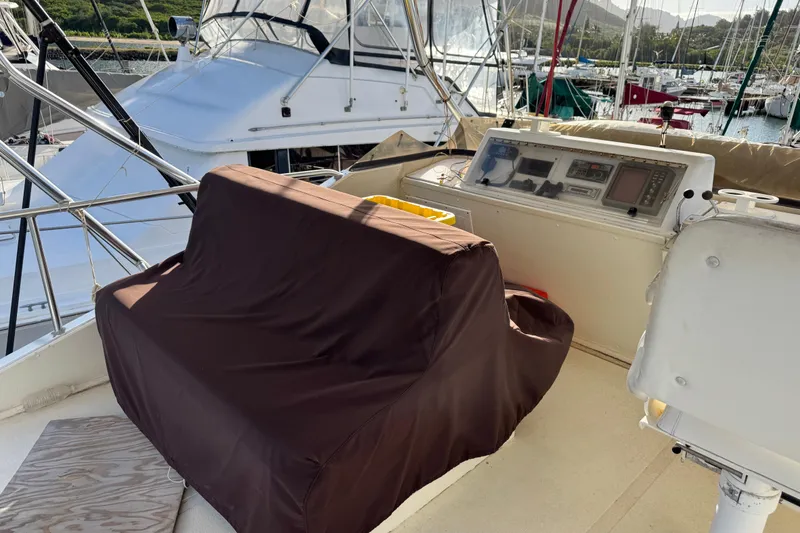 Slide: The Image of 1977 Pacifica 44 Convertible yacht helm with covered seating and control panel in marina. - 19