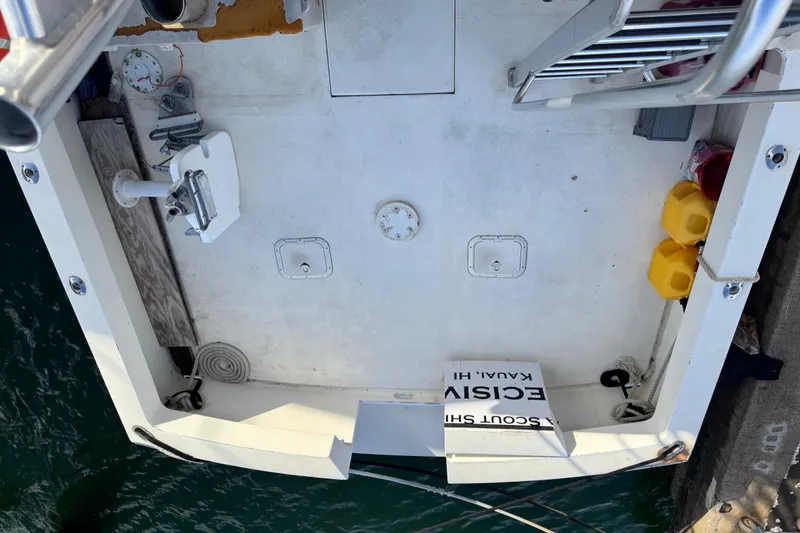 Slide: The Image of 1977 Pacifica 44 Convertible boat deck with equipment and storage, docked by the water. - 23