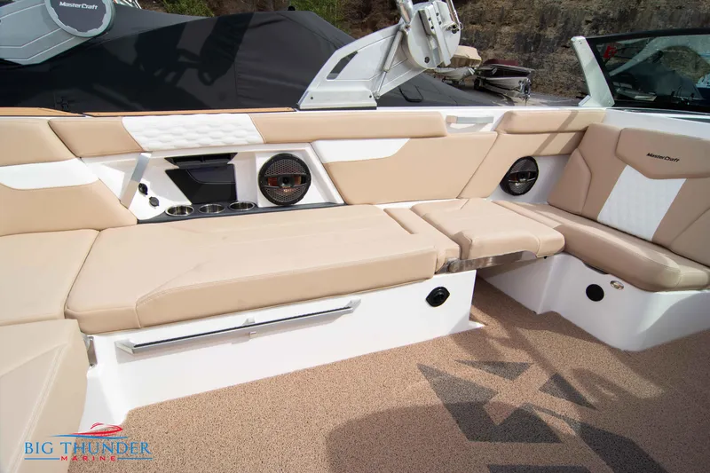 Slide: The Image of 2024 MasterCraft NXT24 boat interior with beige seating and built-in speakers. - 18