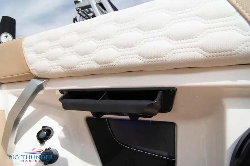 Slide: The Image of 2024 MasterCraft NXT24 boat interior detail with white cushioned seating and storage compartment. - 25