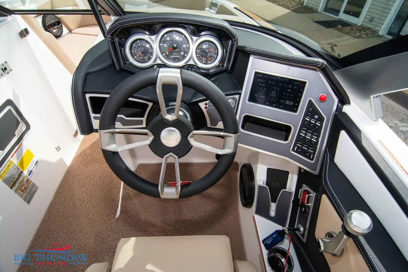 Slide: The Image of 2024 MasterCraft NXT24 boat dashboard with steering wheel and control panel. - 28