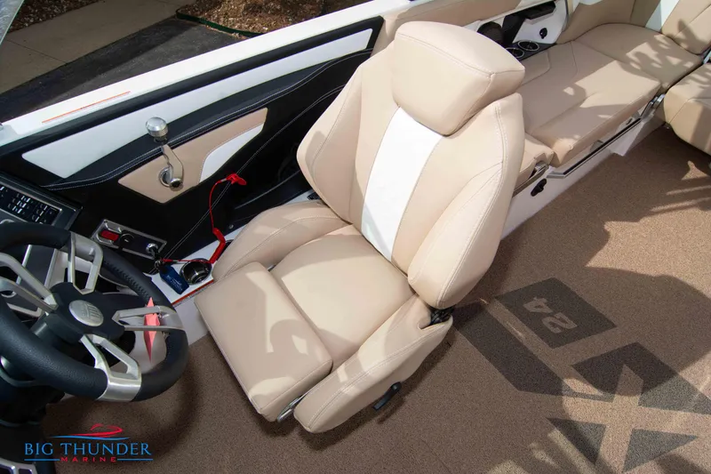 Slide: The Image of 2024 MasterCraft NXT24 boat interior with beige seating and steering wheel. - 34