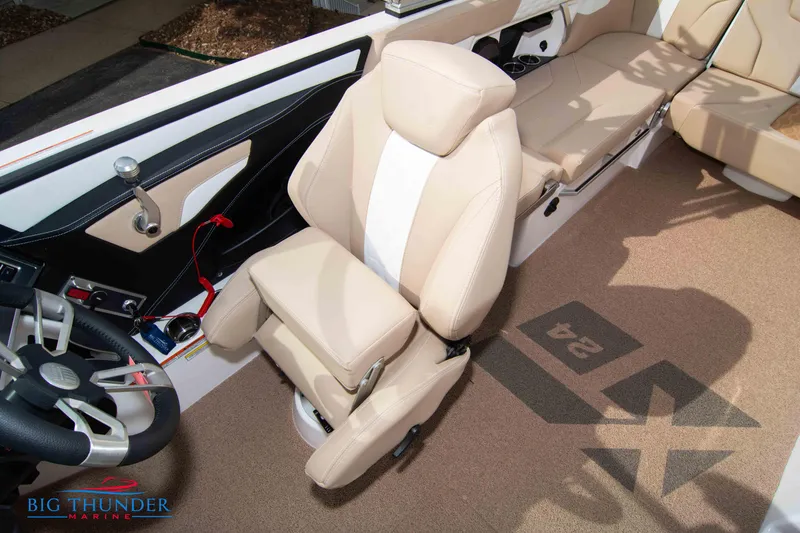 Slide: The Image of 2024 MasterCraft NXT24 boat interior with beige seating and steering wheel. - 35