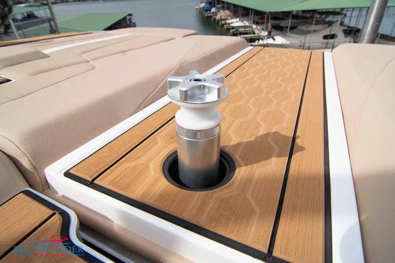 Slide: The Image of 2024 MasterCraft NXT24 boat deck with teak finish and metal fixture, docked at marina. - 46
