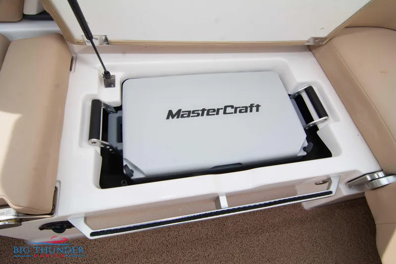 Slide: The Image of 2024 MasterCraft NXT24 boat storage compartment with branded cooler. - 58