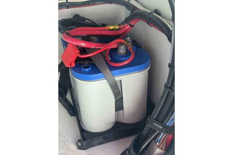 Slide: The Image of Battery setup in 2023 Hell's Bay Marquesa boat with red and black cables. - 12