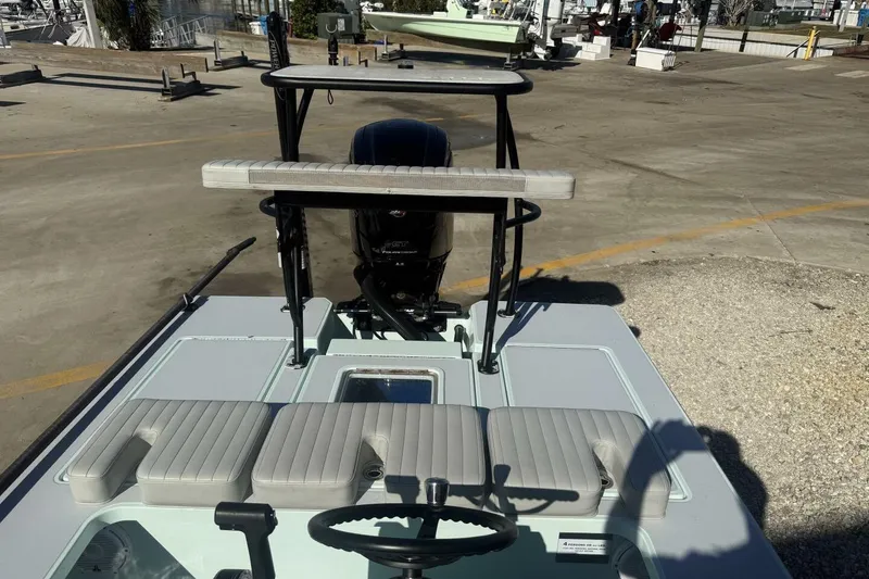 Slide: The Image of 2023 Hell's Bay Marquesa boat with seating and steering wheel, docked on concrete. - 13