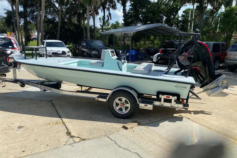 Slide: The Image of 2023 Hell's Bay Marquesa boat on trailer, parked outdoors, surrounded by vehicles. - 3