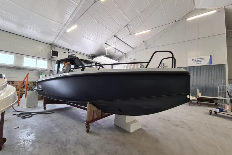 Slide: The Image of 2021 XO Boats DFNDR9 with trailer in a spacious indoor facility. - 1