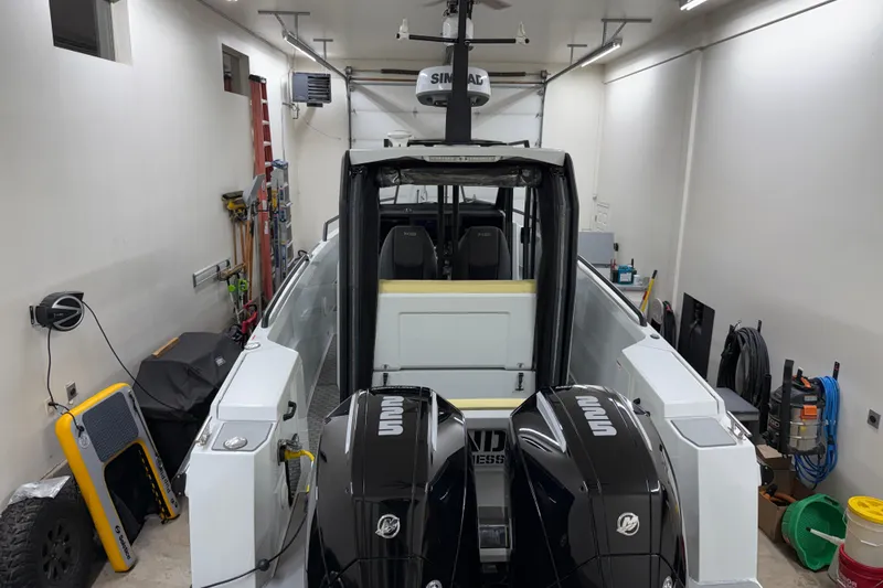 Slide: The Image of 2021 XO Boats DFNDR 9 in garage with dual outboard engines. - 52