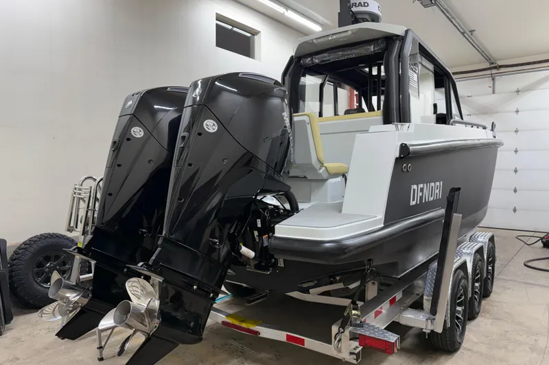 Slide: The Image of 2021 XO Boats DFNDR 9 with dual outboard motors on trailer in garage. - 47