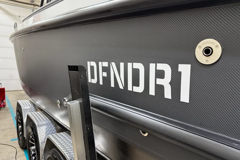 Slide: The Image of 2021 XO Boats DFNDR 9 side view with "DFNDR1" text, on trailer. - 51