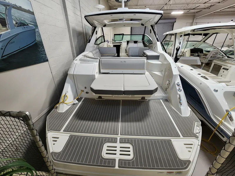 Slide: The Image of 2023 Sea Ray Sundancer 320 in a boat showroom. - 2