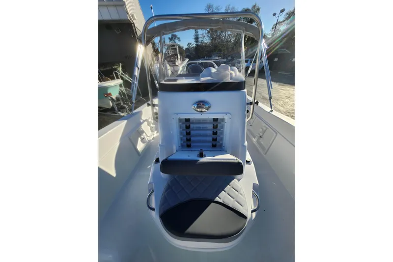 Slide: The Image of 2026 NauticStar 211 Hybrid boat interior with console and seating, under sunny skies. - 6