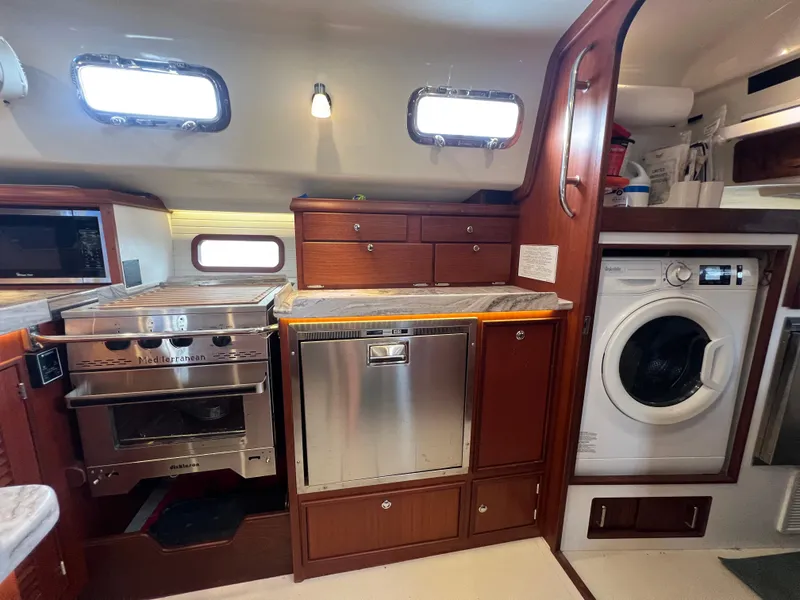 Slide: The Image of Island Packet 439 yacht kitchen with stove, dishwasher, and washer. - 22