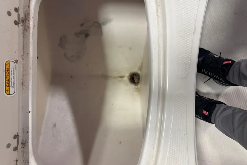 Slide: The Image of 2009 Tahoe 215xi I/O boat interior with caution label and visible footwear. - 2