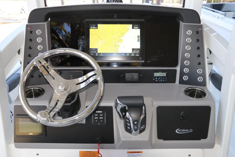 Slide: The Image of 2026 Robalo 246 Cayman boat dashboard with steering wheel, navigation screen, and control panel. - 16