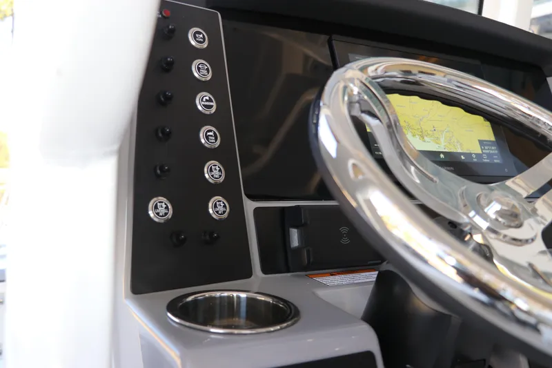 Slide: The Image of 2026 Robalo 246 Cayman boat dashboard with steering wheel and navigation display. - 17