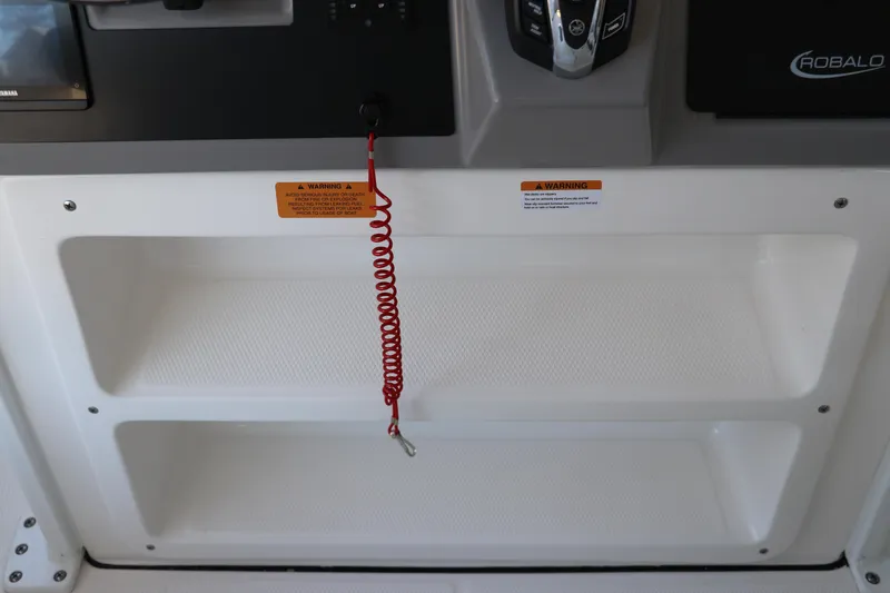 Slide: The Image of 2026 Robalo 246 Cayman boat dashboard with safety warning and red coiled lanyard. - 21