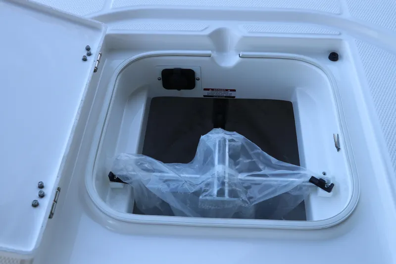 Slide: The Image of 2026 Robalo 246 Cayman boat storage compartment with plastic-covered anchor. - 34