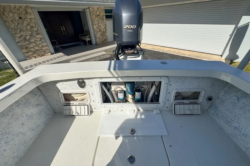 Slide: The Image of 1972 Cuda Craft Open Fisherman boat with Yamaha 200 engine, docked near a garage. - 64