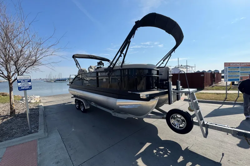 Slide: The Image of 2021 Barletta C22CC pontoon boat on trailer at lakeside launch area. - 13