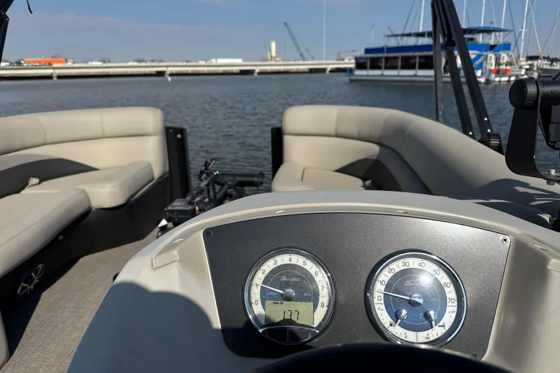 Slide: The Image of 2021 Barletta C22CC boat interior with dashboard and seating, docked at marina. - 14