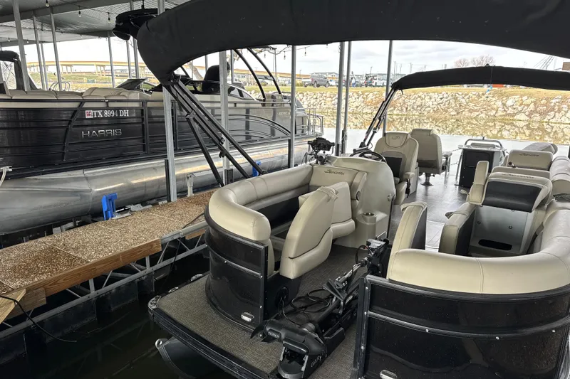 Slide: The Image of 2021 Barletta C22CC pontoon boat docked, featuring spacious seating and modern design. - 16