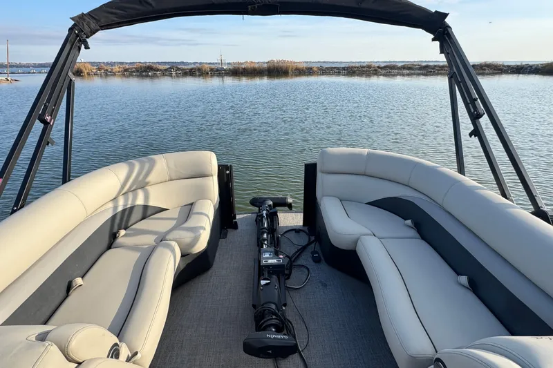 Slide: The Image of 2021 Barletta C22CC pontoon boat interior with plush seating on a serene lake. - 17