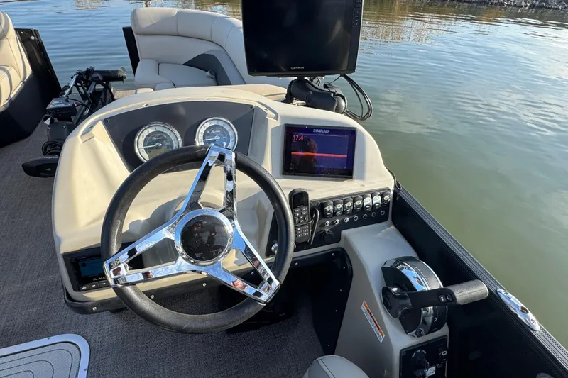 Slide: The Image of 2021 Barletta C22CC boat dashboard with steering wheel and navigation screens. - 26