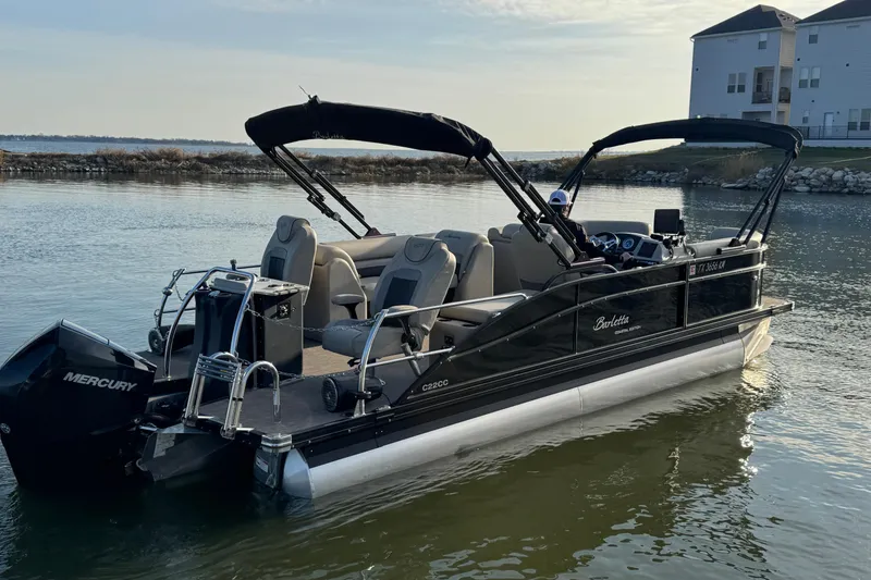 Slide: The Image of 2021 Barletta C22CC pontoon boat on calm water, featuring a Mercury engine. - 3