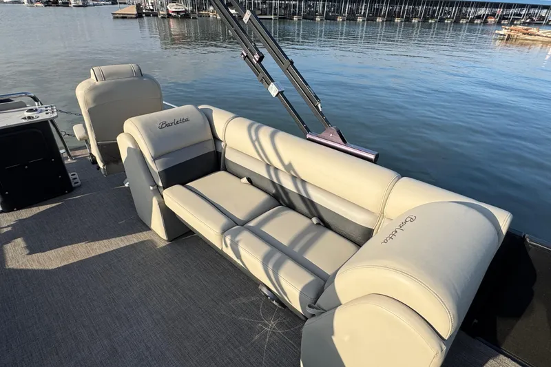 Slide: The Image of 2021 Barletta C22CC pontoon boat with beige seating, docked by the water. - 31