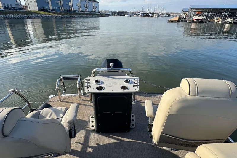 Slide: The Image of 2021 Barletta C22CC pontoon boat interior with seating, table, and water view. - 33