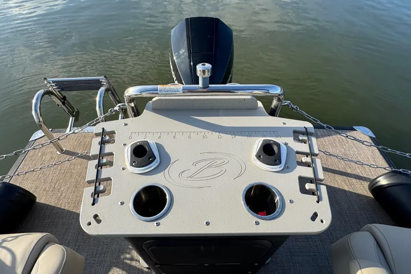 Slide: The Image of 2021 Barletta C22CC boat deck with fishing rod holders and motor, on calm water. - 34