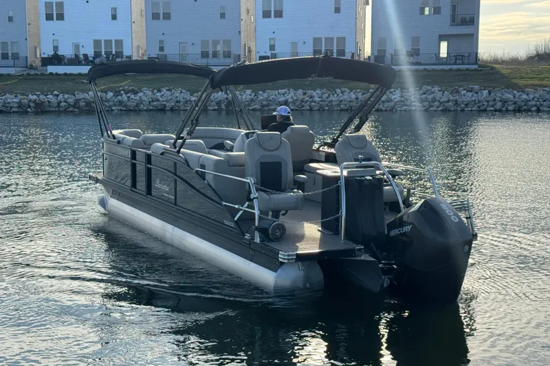 Slide: The Image of 2021 Barletta C22CC pontoon boat cruising on a calm lake near residential buildings. - 5