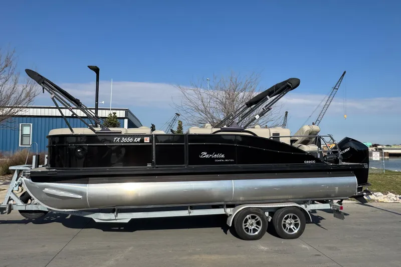 Slide: The Image of 2021 Barletta C22CC pontoon boat on trailer, parked outdoors under clear sky. - 6