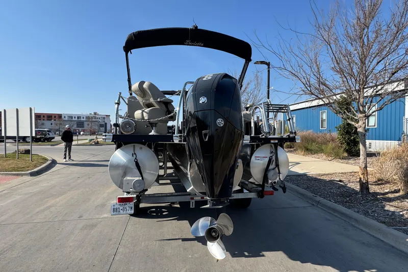 Slide: The Image of 2021 Barletta C22CC pontoon boat on trailer, parked outdoors on a sunny day. - 7