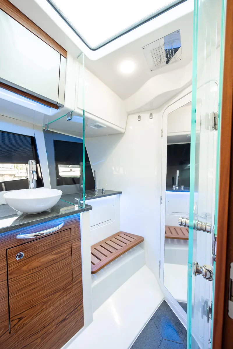 Slide: The Image of 2021 Boston Whaler 405 Conquest interior kitchen with modern wood cabinetry and stainless steel appliances. - 21