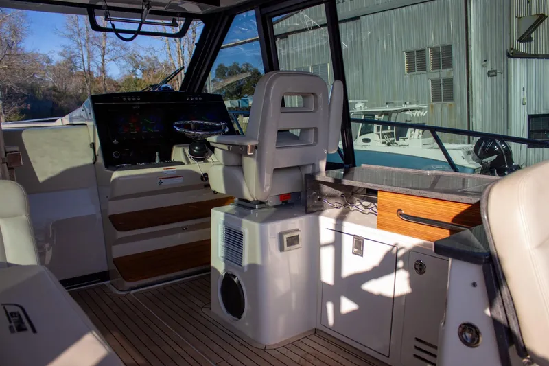 Slide: The Image of Interior of 2021 Boston Whaler 405 Conquest boat, featuring helm and seating area. - 45