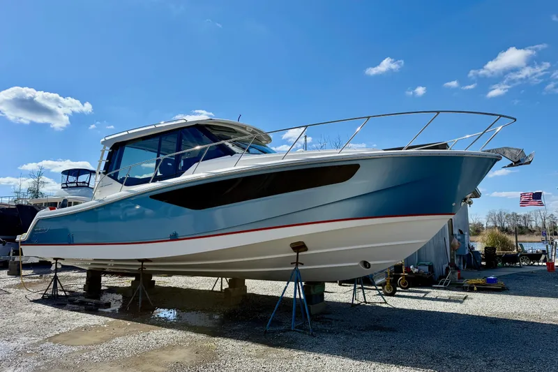 Slide: The Image of 2021 Boston Whaler 405 Conquest boat on stands under a clear blue sky. - 48