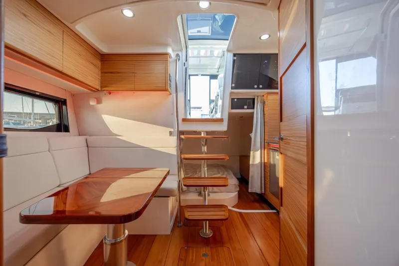 Slide: The Image of Interior of 2021 Boston Whaler 405 Conquest, featuring modern wood finishes and cozy seating area. - 50