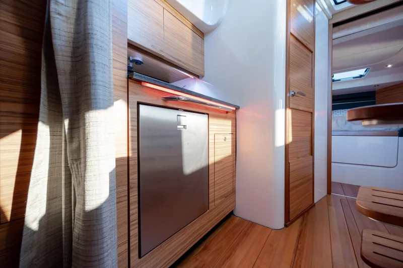 Slide: The Image of Interior of 2021 Boston Whaler 405 Conquest, featuring modern wood cabinetry and stainless steel appliances. - 53