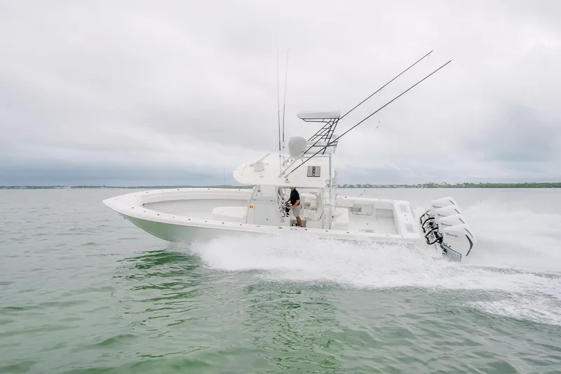 Slide: The Image of 2023 Contender 39 ST boat cruising on open water with fishing rods. - 1