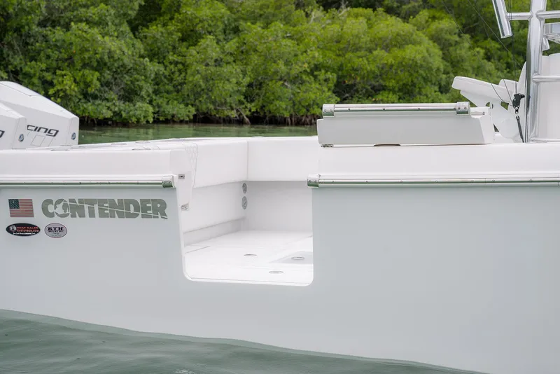 Slide: The Image of 2023 Contender 39 ST boat with sleek design, docked near lush greenery. - 11