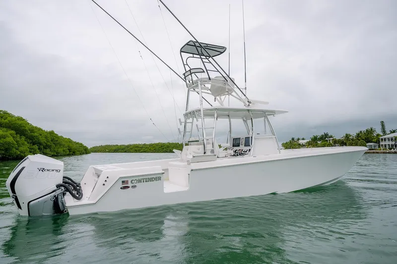 Slide: The Image of 2023 Contender 39 ST boat on water, featuring sleek design and powerful outboard engine. - 13