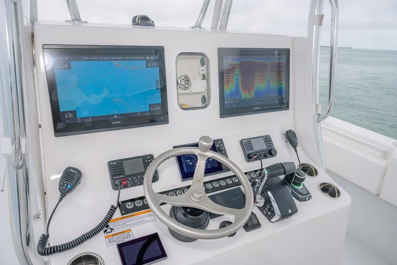 Slide: The Image of 2023 Contender 39 ST boat dashboard with navigation screens and controls. - 14