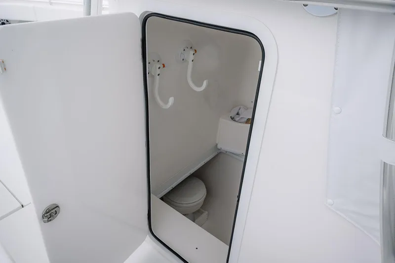 Slide: The Image of 2023 Contender 39 ST boat interior with open door revealing compact bathroom. - 16